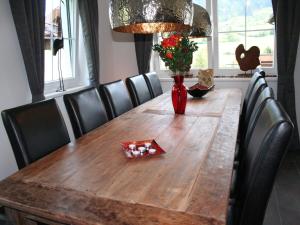 a wooden table with a vase of flowers on it at Holiday Home Brixen near Skiwelt Slopes in Brixen im Thale +25 photos