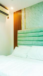 1 dormitorio con cama blanca y cabecero verde en Luxury 3-Bedroom Home in Maitama Abuja, en Abuja
