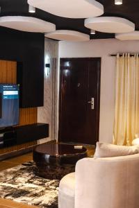 Una sala de estar con un sofá y un televisor. en Luxury 3-Bedroom Home in Maitama Abuja, en Abuja 2 fotos más