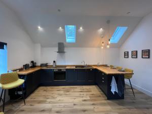 a kitchen with blue cabinets and a sink and a counter at Apple Tree Apartment in Hensol