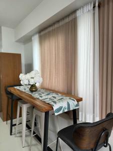 uma mesa de jantar com um vaso de flores sobre ela em Taal Lake View Condo in Tagaytay em Kaybagal