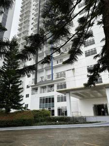 um grande edifício branco com uma risca azul em Taal Lake View Condo in Tagaytay em Kaybagal