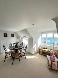 a living room with a table and chairs and the ocean at Serendipity - Sweet home with sweeping sea views in Isle of Wight