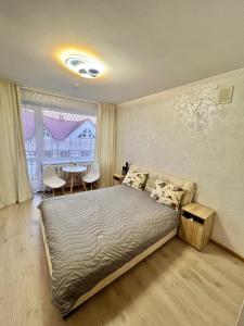 a bedroom with a bed and a table and a window at Удеч in Zhidachov +18 photos