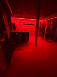 a red room with a table and chairs in front of a brick wall at 69 apartaments BDSM in Panevėžys +5 photos