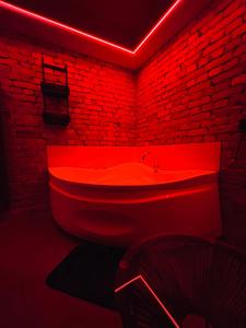 bañera roja en una habitación con pared de ladrillo en 69 apartaments BDSM, en Panevėžys 6 fotos más