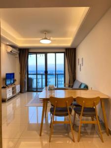 Un comedor con mesa y sillas de madera. en R&F Princess Cove Boutique Homestay By TREX #Nearby CIQ #Johor Bahru #JB Central #To custom 10minit, en Johor Bahru