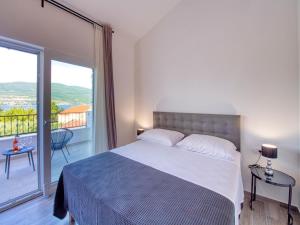 a bedroom with a large bed and a balcony at Villa in Pridraga with Pool near the Sea in Pridraga