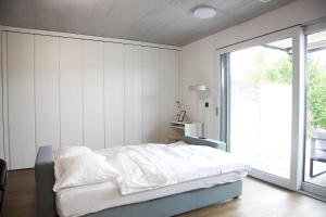 Un dormitorio con una cama y una ventana grande. en Studio 111 loft with views over Aarau, en Aarau