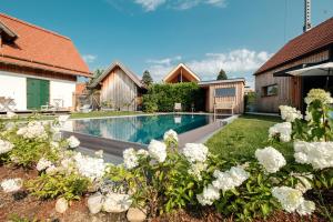 a swimming pool in a yard with white flowers at Ferienhaus Greith79 in Kitzeck im Sausal