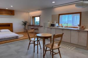 a bedroom with a bed and a table and chairs at 이도스테이 in Sinch'ang-ni