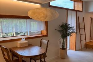 a dining room with a wooden table and a lamp at 이도스테이 in Sinch'ang-ni +23 photos