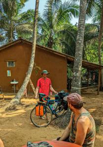a man standing next to a man with a bike at HostelExp, Gokarna - A Slow-Paced Backpackers Community in Gokarna