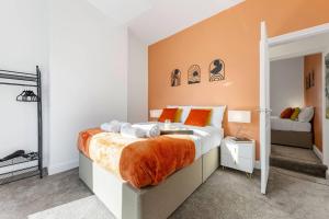 Un dormitorio con una cama tamaño king con sábanas naranjas. en Metrolink Steps Away • Fast City & Airport Links, en Sale