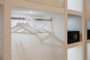 a walk in closet with white hangers and a microwave at B Luxury Home in Castellammare di Stabia