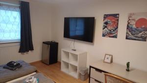 ein Wohnzimmer mit einem Flachbildfernseher an der Wand in der Unterkunft Franken Zimmer in Hallstadt
