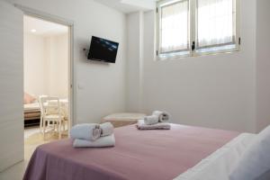a bedroom with a bed with towels on it at B Luxury Home in Castellammare di Stabia