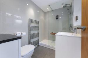 Un baño con inodoro, lavabo y ducha. en Metrolink Steps Away • Fast City & Airport Links, en Sale 39 fotos más