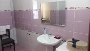 a bathroom with a sink and a mirror at Guest House Netile in Lushnjë