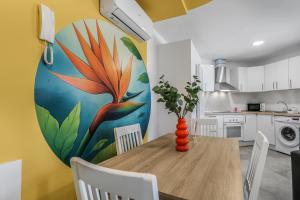 a kitchen with a table with a flower mural on the wall at Penthouse City Hub Stay in Vecindario