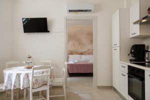 a small white kitchen with a table and a room at B Luxury Home in Castellammare di Stabia