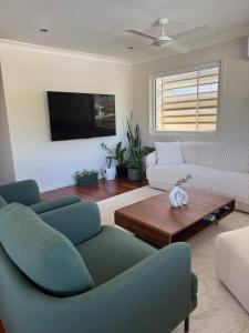 DeagonにあるRoom in a Beautiful Queenslander Houseのソファ2つとテレビのあるリビングルーム
