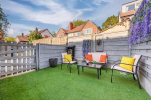 un patio con sillas y una mesa en el césped en Metrolink Steps Away • Fast City & Airport Links, en Sale