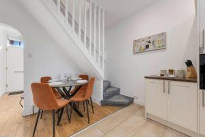 una cocina con una mesa con sillas y una escalera en Metrolink Steps Away • Fast City & Airport Links, en Sale