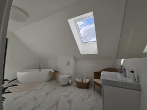 a bathroom with a tub and a sink and a window at W Tarczynach - mazurski dom z widokiem na jezioro in Tarczyny +48 photos