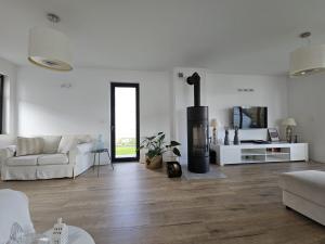 a white living room with a white couch and a fireplace at W Tarczynach - mazurski dom z widokiem na jezioro in Tarczyny