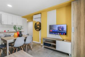 a kitchen with a dining table and a tv on a wall at Penthouse City Hub Stay in Vecindario