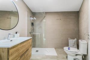 a bathroom with a sink and a toilet and a mirror at Penthouse City Hub Stay in Vecindario +24 photos