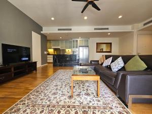 Una sala de estar con un sofá y una mesa de café. en Resort Style Haven 3BR6pax St Mary KLCC Twin Towers View, en Kuala Lumpur