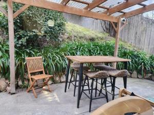 Una mesa y sillas de madera en un patio. en Bowen Toft Villa- New Listing, en Sandy Bay