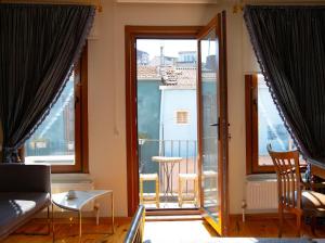 イスタンブールにあるFatih Balat tarihin içinde şık bir ev 2のソファと大きな窓のあるリビングルーム +4枚の写真