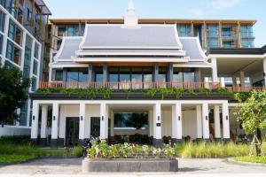 a large white building with flowers in front of it at Ozone Sky View Residence in Laguna Phuket