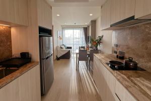 a kitchen with a counter and a table in a room at Ozone Sky View Residence in Laguna Phuket