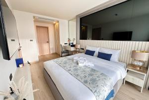 a bedroom with a large bed and a desk at Ozone Sky View Residence in Laguna Phuket +45 photos