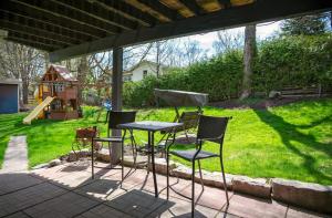 a table and chairs on a patio with a playground at Majestic Maples - Quiet oasis with 2 king beds in Port Perry