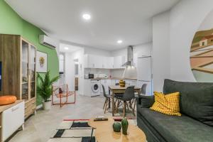 ベシンダリオにあるCity Hub Stayのソファとテーブルのあるリビングルームとキッチン