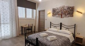a bedroom with a bed with two towels on it at Roma Tourist Lease in Acilia