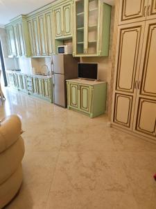 a large kitchen with green cabinets and a refrigerator at Modern Comfort in Old Tbilisi in Tbilisi City