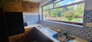 a small kitchen with a sink and a window at Andover Garden Bungalow in Penton Mewsey