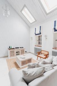 a living room with white walls and white furniture at Oficyna Ciekocinko in Ciekocinko +22 photos