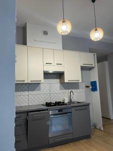 a kitchen with white cabinets and a stove top oven at Stara słodownia in Grodków