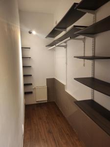 a room with shelves and a hallway with wooden floors at Stara słodownia in Grodków