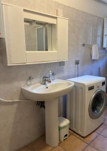 a bathroom with a sink and a washing machine at Casa Gallina in Introdacqua +18 photos