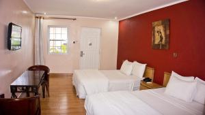 a hotel room with two beds and a table at Tropical Enclave Hotel in Accra
