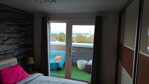 a bedroom with a sliding glass door to a balcony at The Bridge in Dartford