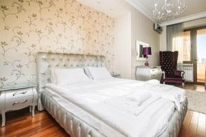 埃里温Katsin Building ! 3 Bedroom Luxury Apartment with 2 Bathrooms!的卧室配有一张带吊灯的大型白色床。